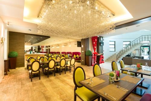 a restaurant with tables and chairs and a staircase at Lenox Hotel in Dagupan