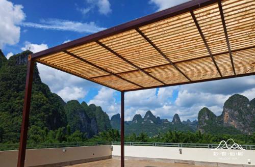 a wooden pergola with a view of vimy mountains at Melody Inn in Yangshuo