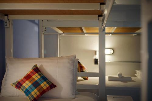 a bunk bed with a pillow sitting next to a bunk bed at Luck Esan Loft in Ubon Ratchathani