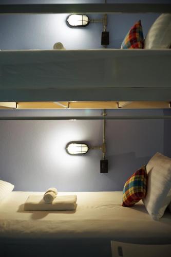 a room with a bed with two lights on it at Luck Esan Loft in Ubon Ratchathani