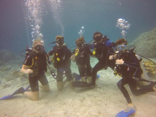 a group of people in scuba gear standing in the sand at Blue Shark Divers Bunaken in Bunaken