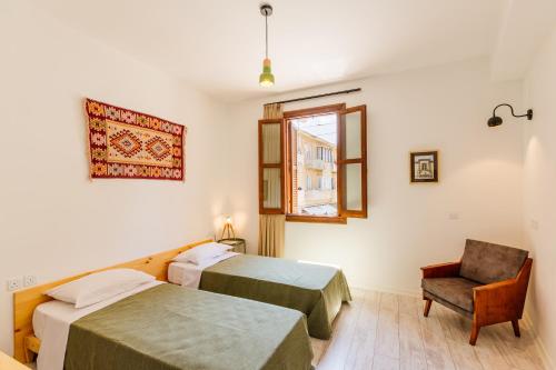 um quarto de hotel com duas camas e uma cadeira em Djumba Hotel & Cafe em Lefkosa Turk