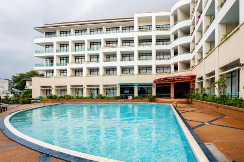 a swimming pool in front of a building at Surin Majestic Hotel in Surin