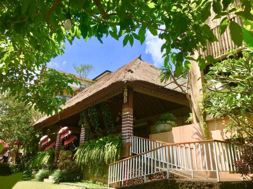 a house with a gazebo in the yard at Hotel Puriartha Ubud in Ubud
