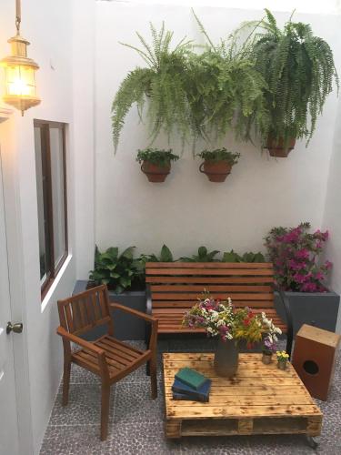 a patio with a bench and a table and potted plants at Belma Boutique Bed and Breakfast in Lima