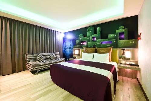 a bedroom with a large bed and a chair at ZC Motel in Taoyuan