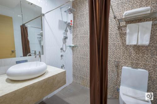 a bathroom with a white sink and a shower at Bed and Bath Serviced Suites in Iloilo City