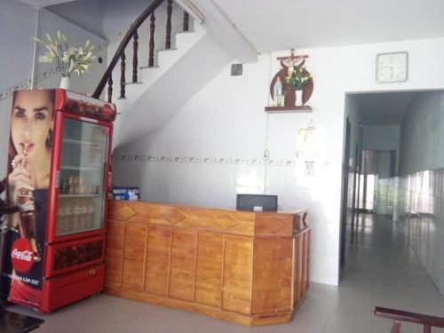 a room with a coke machine next to a wooden cabinet at Minh Duc Guesthouse in Phan Thiet