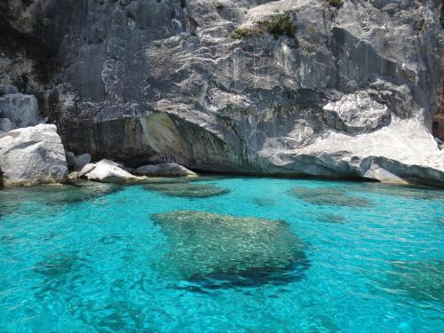 a pool of blue water in front of a cliff at B&B Fradama' Holiday in Dorgali