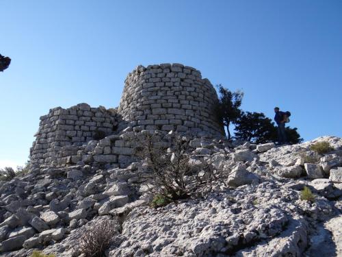 a person standing on top of a rocky mountain at B&B Fradama' Holiday in Dorgali