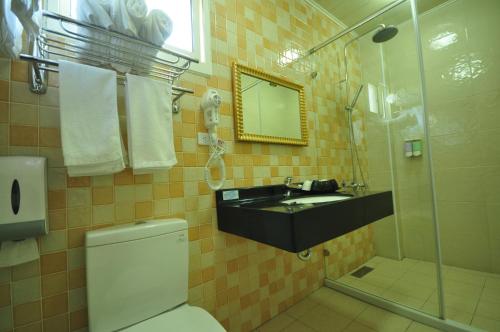 a bathroom with a sink and a toilet and a shower at Seasons Homestay in Xiaoliuqiu