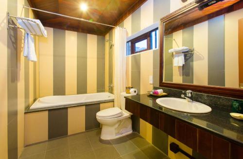 a bathroom with a sink and a toilet and a mirror at Hoi An Garden Villas in Hoi An