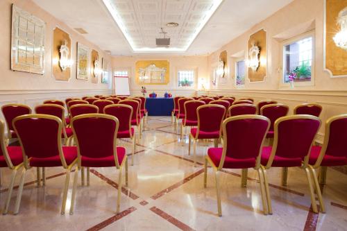 a conference room with red chairs and a table at Hotel Principe in Venice