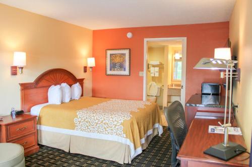 Habitación de hotel con cama y escritorio en Rose Garden Inn & Suites Thomasville en Thomasville