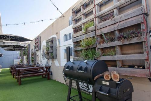 a grill on the side of a building with benches at Motel Nomad in Cairns