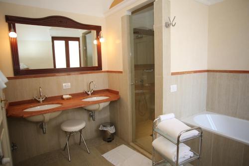 a bathroom with two sinks and a shower and a tub at Palazzo Iaquinto in Santa Maria di Castellabate
