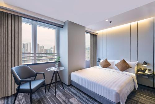 een hotelkamer met een bed en een stoel bij Hotel COZi Oasis in Hong Kong