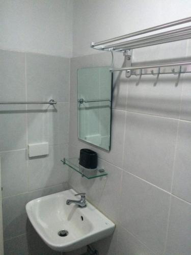a white bathroom with a sink and a mirror at Unit 1109 Cityscape Residences in Bacolod