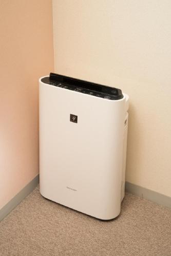 a white refrigerator sitting in the corner of a room at Hotel Yassa in Mihara