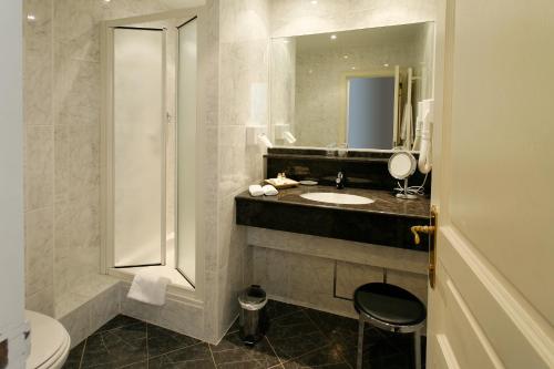 a bathroom with a sink and a toilet and a mirror at La Villa des Fleurs in Spa