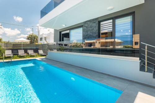 a swimming pool in the backyard of a house at Nisos Villa, Pool & Heated SpaWhirlpool, Walking to Beach, By ThinkVilla in Sfakaki