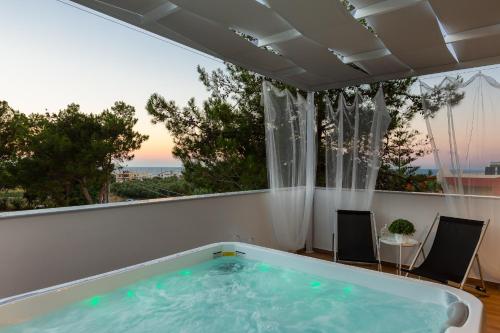 a hot tub in a room with a large window at Nisos Villa, Pool & Heated SpaWhirlpool, Walking to Beach, By ThinkVilla in Sfakaki