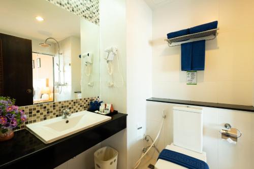 a bathroom with a sink, toilet, and bathtub at Vogue Pattaya Hotel in Pattaya