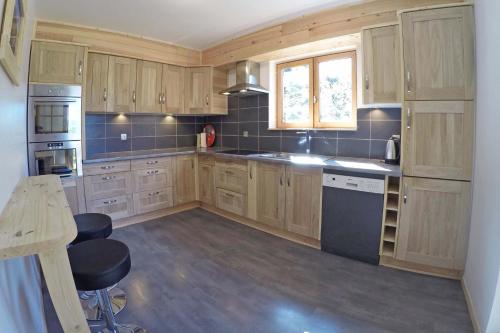 a large kitchen with wooden cabinets and a table at Serre Che Chalet in Briançon