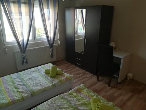 a bedroom with two beds and a mirror and a desk at Apartman Srce in Daruvar