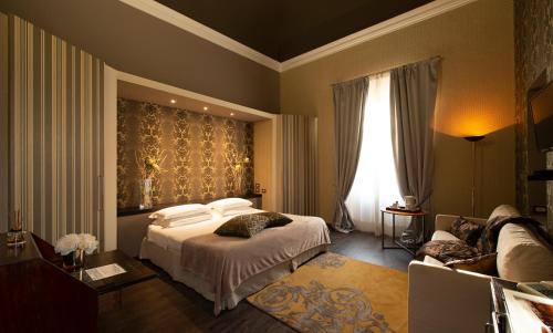 Habitación de hotel con cama y sofá en Hotel De La Pace, Sure Hotel Collection by Best Western, en Florencia