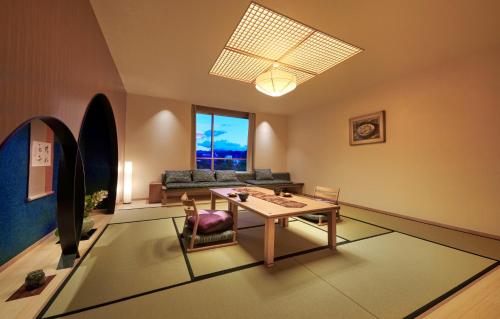 a living room with a table and a couch at Honjin Hiranoya Kachoan in Takayama
