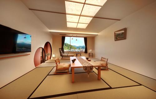 a living room with a table and chairs at Honjin Hiranoya Kachoan in Takayama