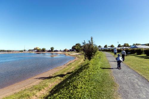 a group of people walking along a path next to the water at First Camp Gränna - Vättern in Gränna