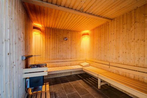 a sauna with wooden walls and benches in a room at Vacancéole - Le Privilège in Germ