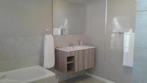 a bathroom with a sink and a mirror and a tub at Ledges Retreat in Bergville