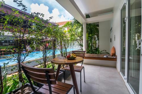a balcony with a table and chairs and a pool at Indra Angkor Residence in Siem Reap