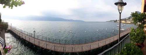 a bridge over a body of water with boats on it at Hotel Garnì Bartabel in Gargnano