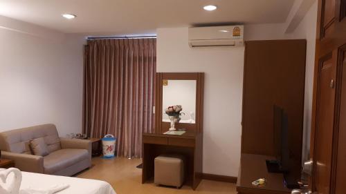 a room with a bed and a chair and a mirror at Nut Mansion Suvarnabhumi in Bang Phli