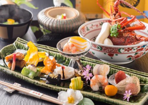 a tray of sushi and vegetables on a table with chopsticks at Honjin Hiranoya Kachoan in Takayama