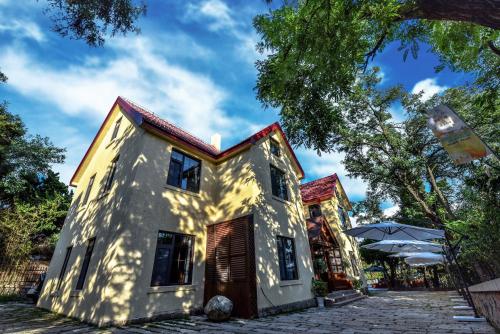 a white house with a tree and an umbrella at Nordic Memory in Qingdao in Qingdao