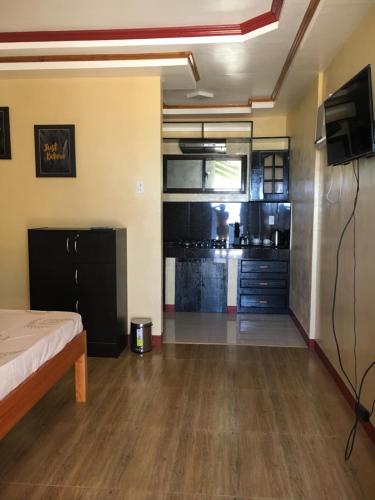 a living room with a bed and a kitchen at Kobe's Beachfront Haven in Siquijor