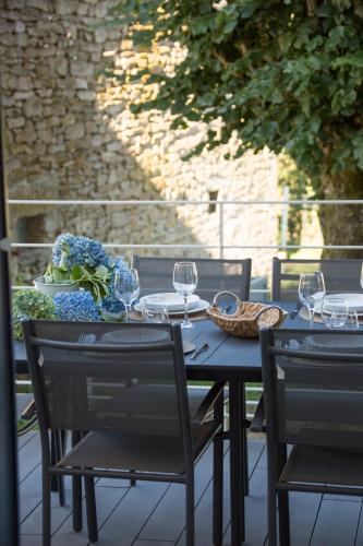 - une table avec 2 chaises et des verres à vin dans l'établissement Le Domaine de Mandrin, à Madranges