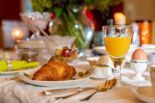 a table with a plate of food and a glass of orange juice at Beck's Bed and Breakfast in Kaatsheuvel