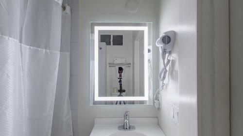 a white bathroom with a sink and a mirror at Warfield Hotel in San Francisco