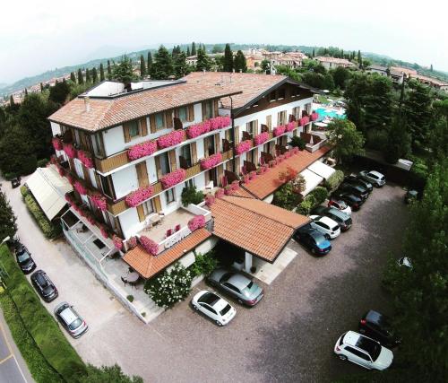 an aerial view of a building with cars parked in a parking lot at Parc Hotel Casa Mia in Lazise