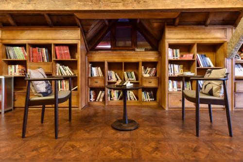 a library with two tables and shelves of books at Nordic Memory in Qingdao in Qingdao
