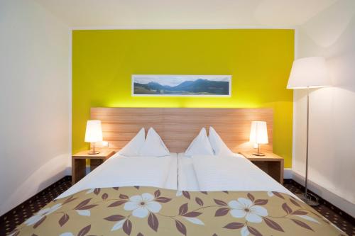 a hotel room with a bed with two lamps at Alphotel Innsbruck in Innsbruck