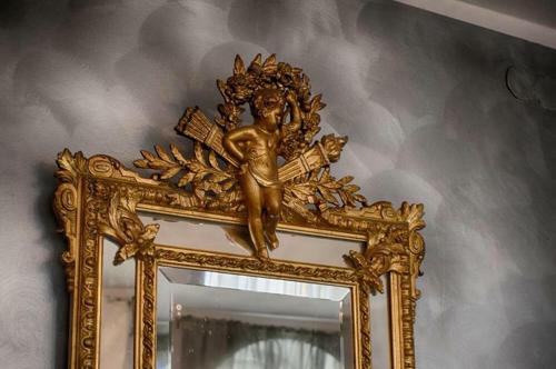 a gold mirror with a statue of a cross on it at Villa Romeo in Brzeg