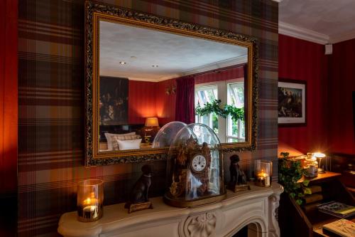un espejo sobre un manto con un reloj y velas en Beck's Bed and Breakfast, en Kaatsheuvel