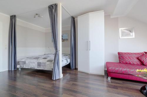 ビンツにあるVilla-Strandidyll-Typ-1 / Apartment 15のベッドルーム1室(ベッド1台、赤いソファ付)